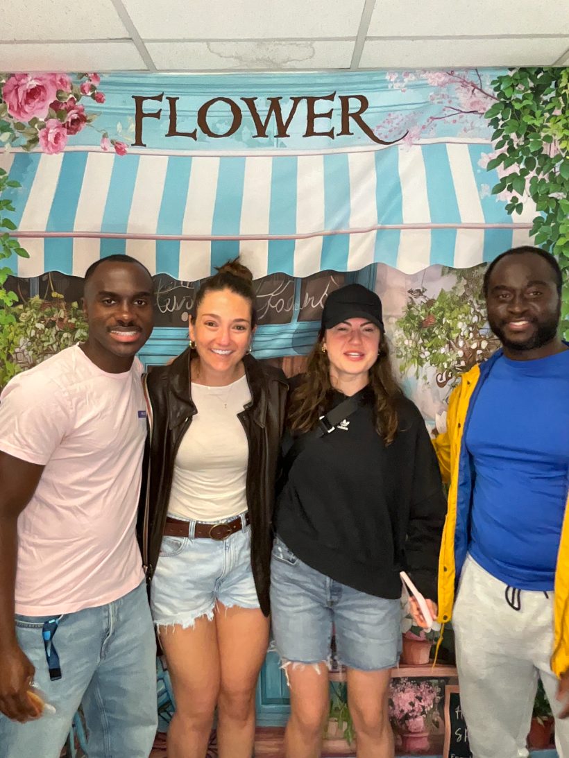 Four friends posing together at the spring photo backdrop