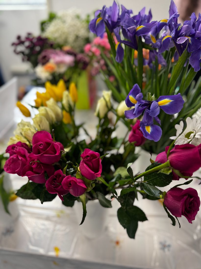 Irises, roses and tulips in buckets at the flower table